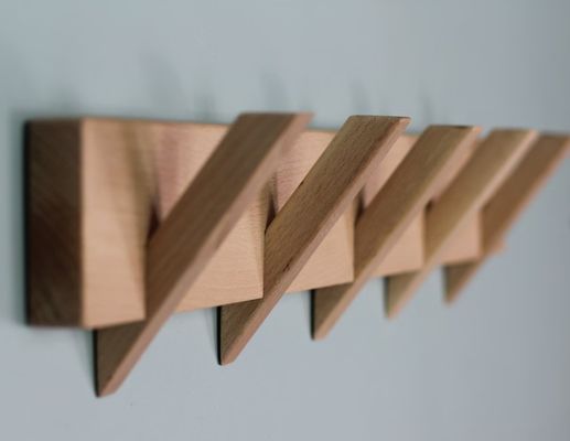 Organización de baño elegante y sostenible con este portaabrigos de madera montado en la pared