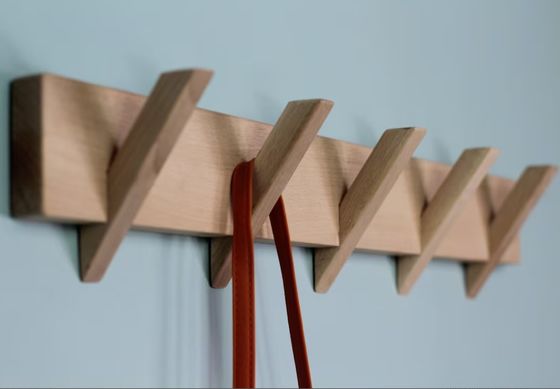 Organización de baño elegante y sostenible con este portaabrigos de madera montado en la pared