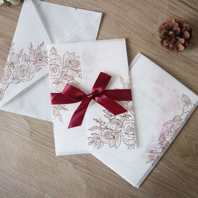 Invitaciones de bodas cortadas con láser de pergamino vegetal con patrón de rosa y estampado térmico