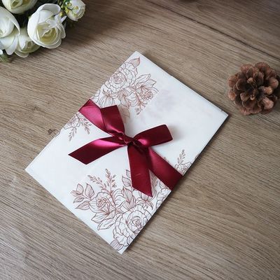Invitaciones de bodas cortadas con láser de pergamino vegetal con patrón de rosa y estampado térmico